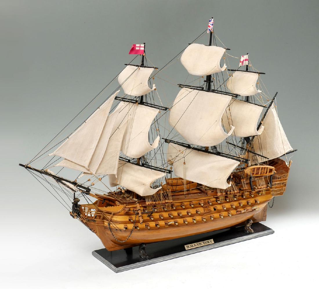 ENGLISH H.M.S. VICTORY SHIP MODEL: ENGLISH H.M.S. VICTORY SHIP MODEL: Wooden ships model of H.M.S. Victory having elaborate rigging work & detail, surmounted by 3 British flags. Brass cannons at both sides. Cannons rest loosely in posi