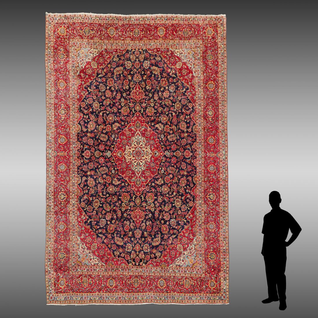 PERSIAN HAND KNOTTED WOOL RUG, 9: PERSIAN HAND KNOTTED WOOL RUG, 9'10" X 14'7": Red and ivory central medallion and corners around a blue field covered with flower heads and palmettes. Red and ivory borders complete the rug.