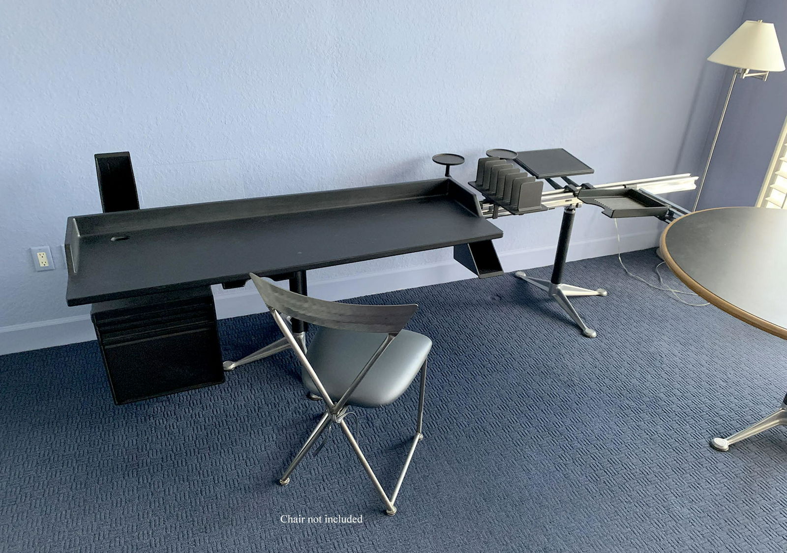 HERMAN MILLER BRUCE BURDICK GROUP MODULAR DESK GROUP:: HERMAN MILLER BRUCE BURDICK GROUP MODULAR DESK GROUP: To include black desk, modular file cabinet, two I-Beam mounting rails, round table/ desk, and 3 pedestals. Also sold with assorted file and book