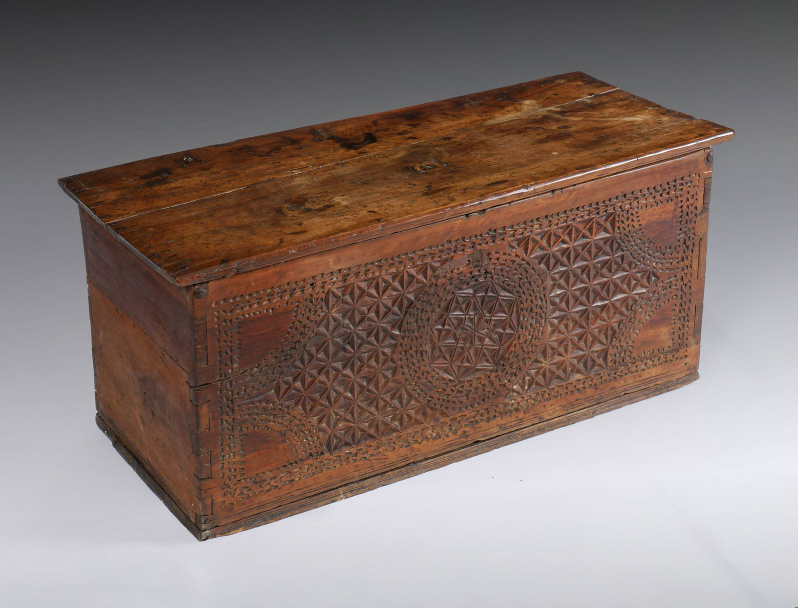 EARLY CARVED SYRIAN TRUNK: EARLY CARVED SYRIAN TRUNK: Old Syrian chest having a carved geometrical design at the observe. Hand forged iron hinges, lower compartment interior. Approx. 16.5'' h x 40.5'' l x 17.5'' w.