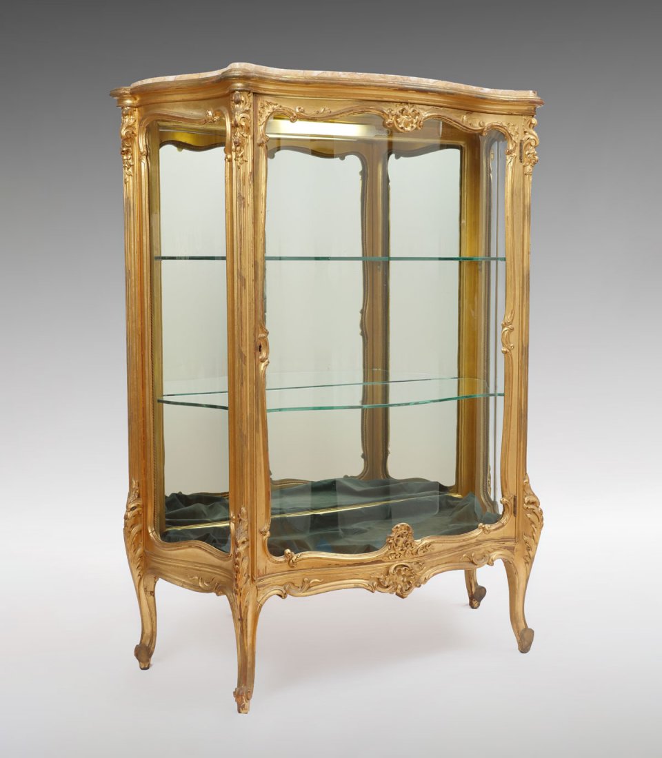 CARVED GILT MARBLE TOP DISPLAY: CARVED GILT MARBLE TOP DISPLAY: Marble top display case having an overall Gilt scrolling foliate design with contoured glass front & sides, 2 shelf mirrored back interior. Approx. 54" h x 42.5" l x 17