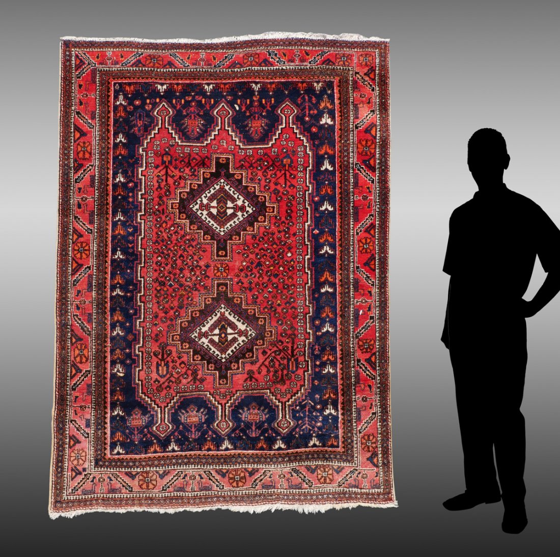 SEMI-ANTIQUE PERSIAN SHIRAZ HAND KNOTTED WOOL RUG: SEMI-ANTIQUE PERSIAN SHIRAZ HAND KNOTTED WOOL RUG, 5' X 6'9": This pretty rug has a red/rust central field with dark blue outer field and two stepped star shaped medallions and lots of small stylized 