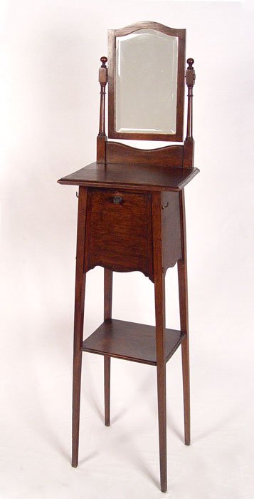 19th c ARTS & CRAFTS SHAVING STAND WITH MIRROR: 19TH C ENGLISH ARTS & CRAFTS SWIVEL TOP SHAVING STAND: Beveled mirror hangs between arms, top of stand pivots, front falls open for storage. Sold with certificate by British Antique Exporters Limited.
