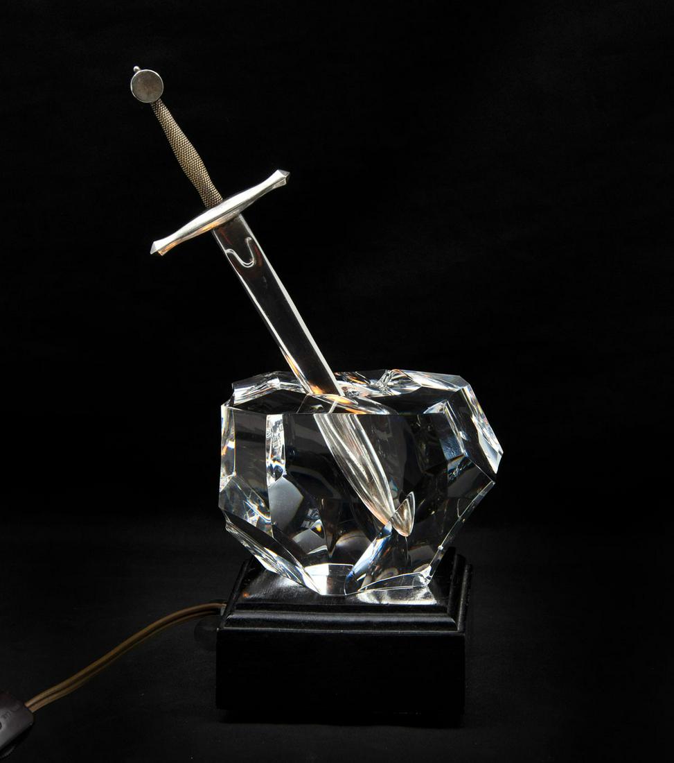 STEUBEN CRYSTAL & STERLING EXCALIBUR LETTER OPENER: STEUBEN CRYSTAL & STERLING EXCALIBUR LETTER OPENER: 18 KT plated Sterling Steuben Excalibur sword resting in a boulder form crystal. All resting on a black wood lighted base. Approx. 10.25" h x 5.5" l