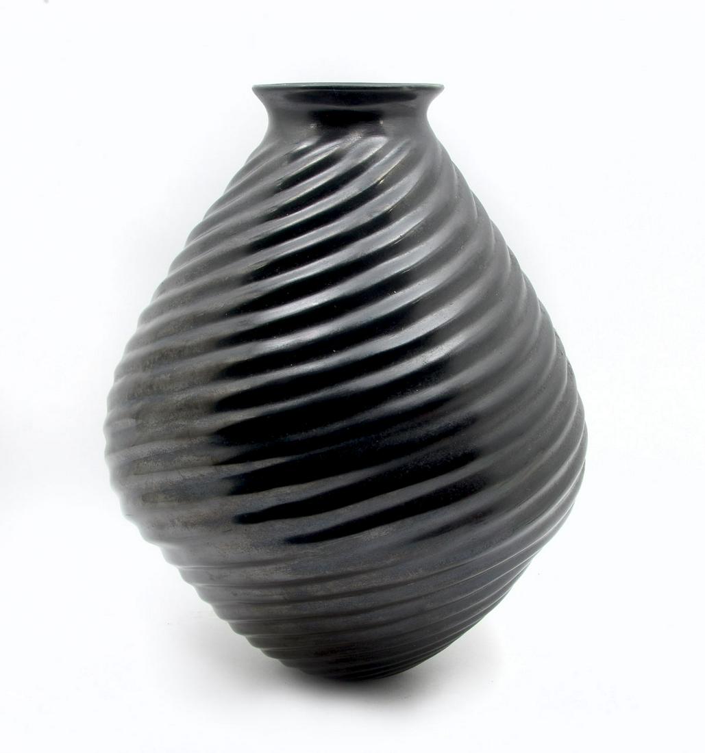 SOUTHWEST INDIAN POTTERY: SOUTHWEST SIGNED INDIAN POTTERY: Large blackware Southwest American Indian vase, having an overall spiraling ribbed design. Signed at underside, Samuel J. Quezada. Approx. 14" h x 10.5" w.