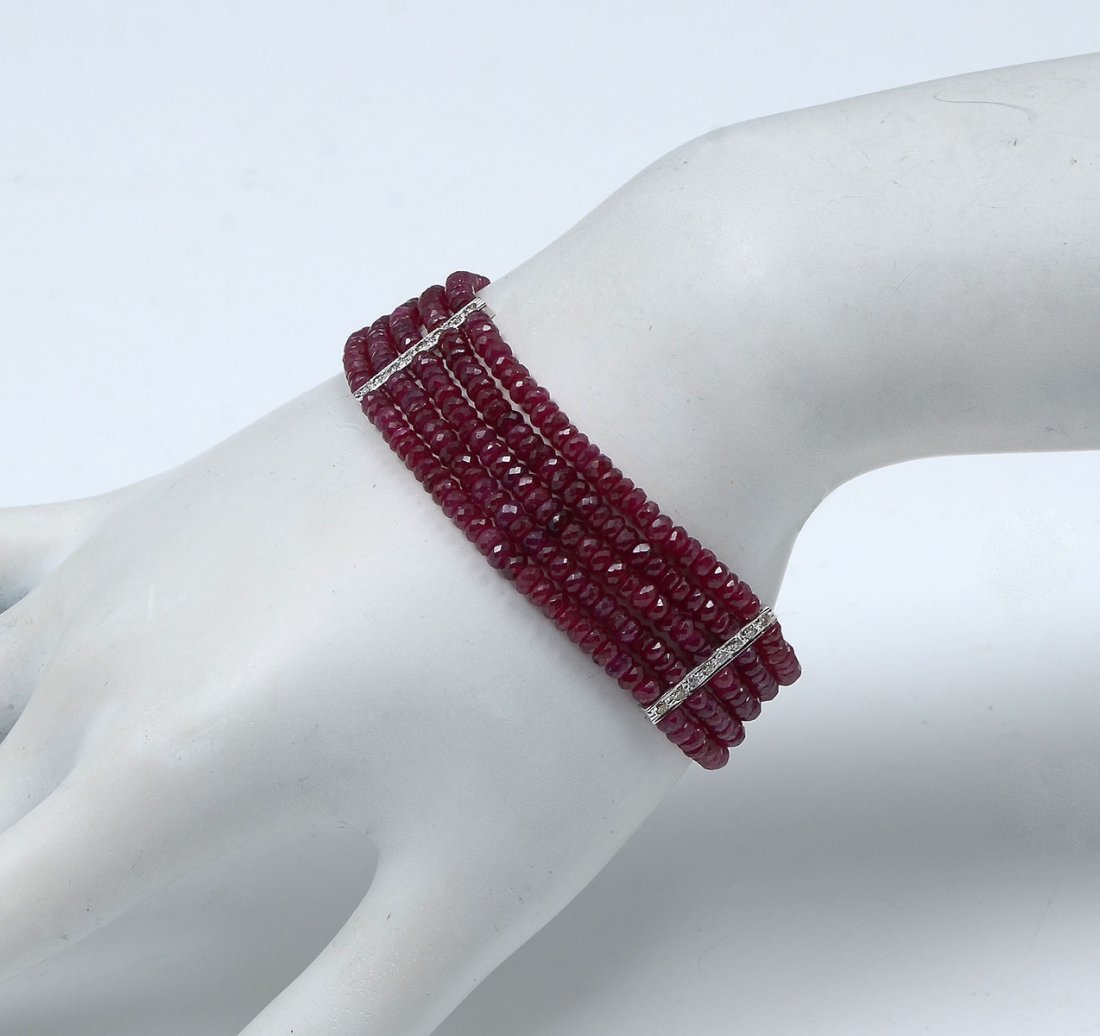 5 STRAND 18K RUBY & DIAMOND BRACELET: 7.25" long. 5 STRAND 18K RUBY & DIAMOND BRACELET: 5 strands of micro, faceted rubies are punctuated by vertical bars of 18K white gold set with diamonds, ending with an 18K white gold clasp set with d