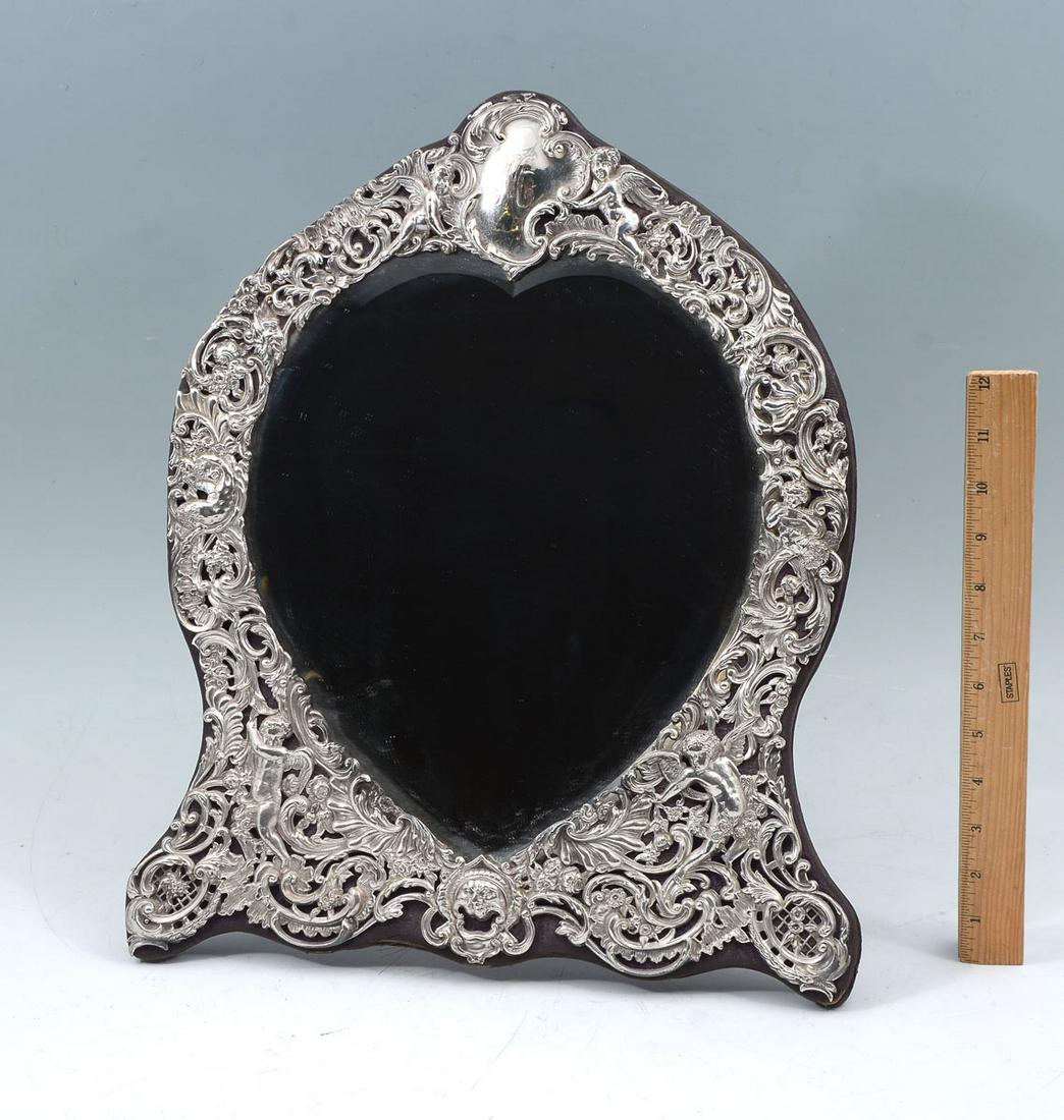 ELABORATE 19TH C. ENGLISH FIGURAL STERLING MIRROR: ELABORATE 19TH C. ENGLISH FIGURAL STERLING MIRROR: English Sterling dresser mirror, having a scrolling foliate designed Sterling frame with Greenman, Putti, & Fauns throughout. Beveled Heart-shaped mi