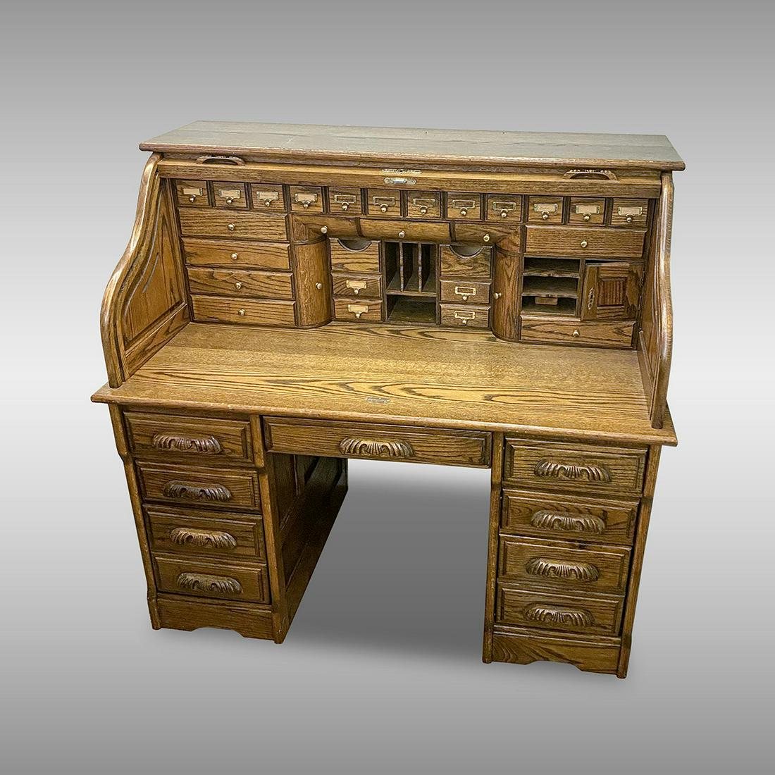 GOLDEN OAK S-ROLL DESK: GOLDEN OAK S-ROLL DESK: Golden Oak S-roll top desk, having a compartmented interior, over 9- drawer lower section. Approx. 50.5" h x 54" l. TO BE SOLD IN PLACE