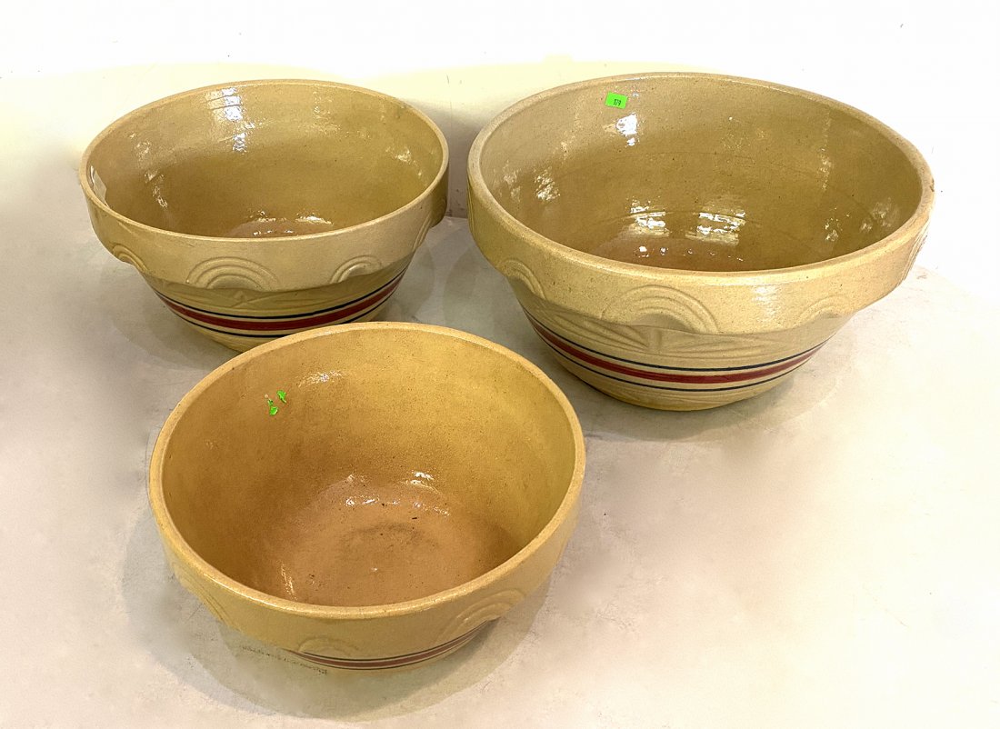 3 PC. ROSEVILLE STONEWARE MIXING BOWLS: 3 PC. ROSEVILLE STONEWARE MIXING BOWLS: 3- Graduated glazed mixing bowls, by R. Ransbottom, for Roseville pottery, of Ohio, having encompassing red & blue glazed accents. Impressed & stamp marks at un