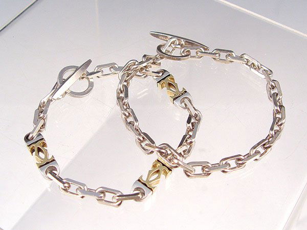 CARTIER 18K AND STERLING LINK BRACELETS: CARTIER 18K AND STERLING LINK BRACELET: Oval and CC links, 8 1/2"l., marked Cartier on ring and Sterling 18k on bar. Sold with a matching oval link bracelet, 9"l., marked Sterling on bar.