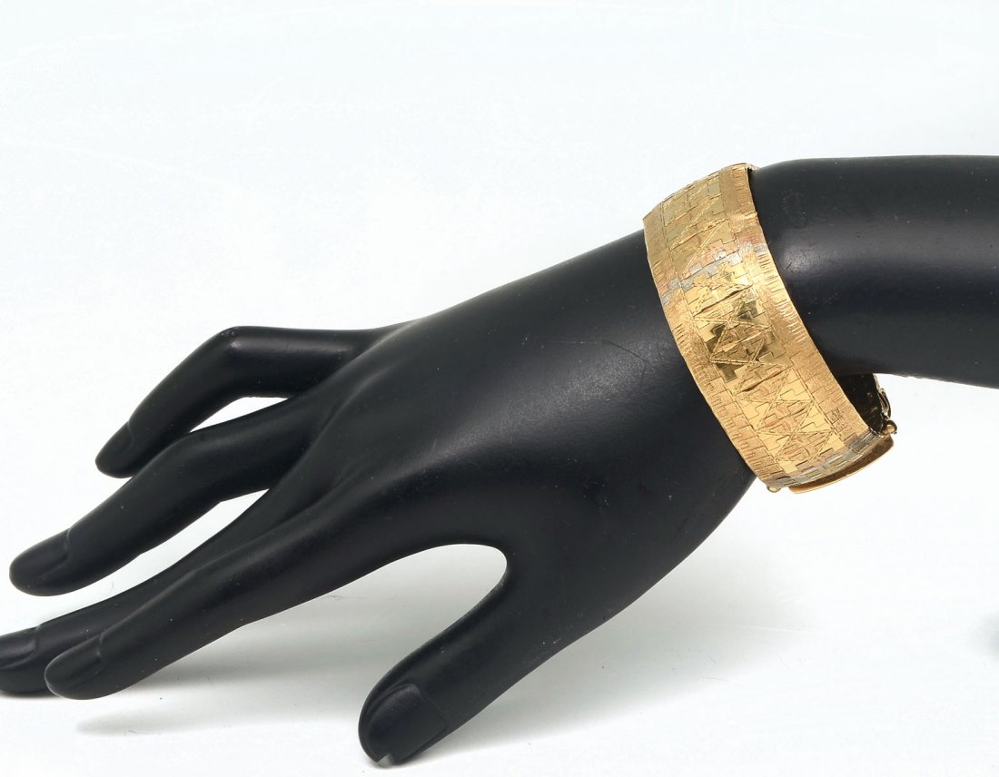 18K 55.2 GRAM TRI COLOR CUFF BRACELET: 18K 55.2 GRAM TRI COLOR CUFF BRACELET: Intricately patterned 18K yellow gold bracelet with rose gold edges and 4 vertical stripes of white gold. 7.25" in length and .875" wide. Etched design. Weight 5