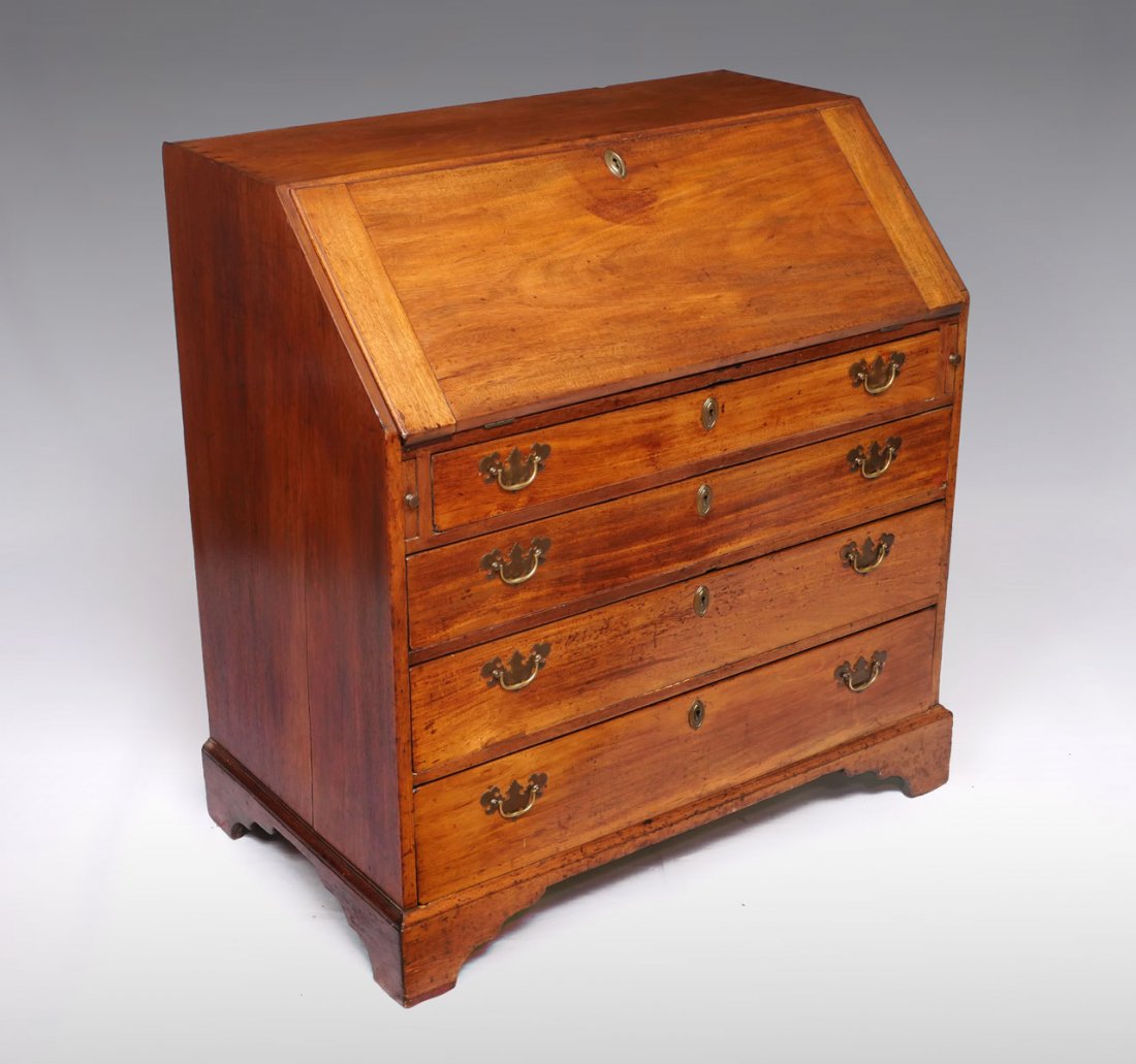 DROP FRONT SECRETARY DESK: DROP FRONT SECRETARY DESK: Drop front secretary with lid that opens to reveal a compartmented interior, over 4- graduated drawers with brass bail handles. Raised on Ogee bracket feet. Approx. 43.75" h