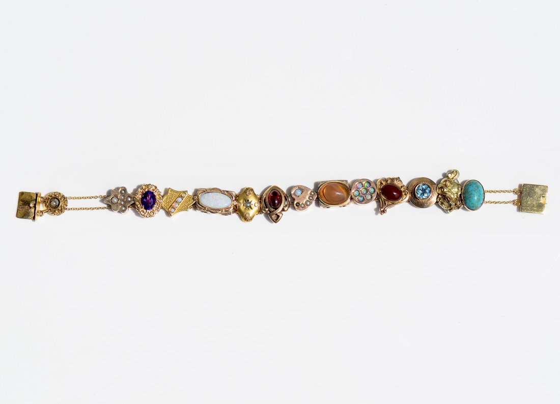 14K GOLD MULTI-GEMSTONE SLIDE BRACELET: 14K GOLD MULTI-GEMSTONE SLIDE BRACELET: 13 Slides containing Opals, Garnets, Seed Pearls and even an Art Nouveau Maiden's head with a rose in her hair. 6.75'' l, 20.8g TW.