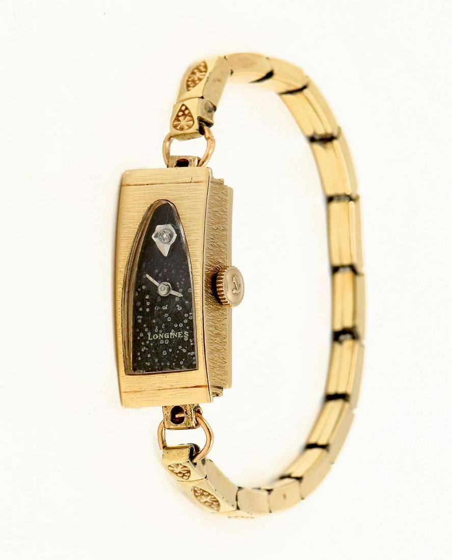 VINTAGE 14K GOLD DIAMOND LONGINES DECO WATCH: VINTAGE 14K GOLD DIAMOND LONGINES DECO WATCH: Yellow gold watch marked 14K gold on case with Speidel non-gold band. Interesting shaped crystal with galaxy like dial face. Diamond? at 12 o'clock. Appro