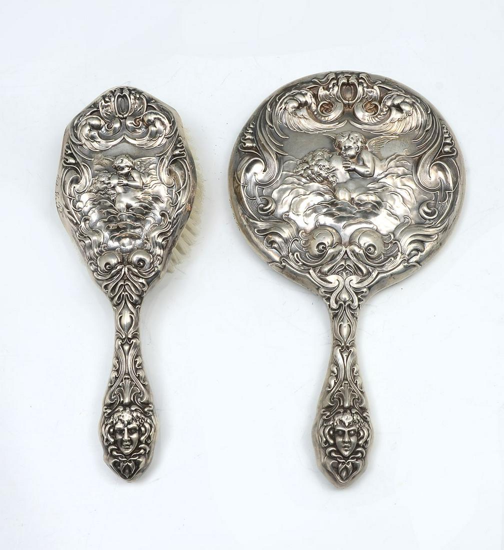 UNGER BROS. LOVE'S DREAM STERLING MIRROR AND BRUSH: UNGER BROS. LOVE'S DREAM STERLING MIRROR AND BRUSH: Ca. 1872-1919. Intricate sterling repousse Art Nouveau design of a woman figure in the clouds, being kissed by cupid, with dolphins, masqueron and w