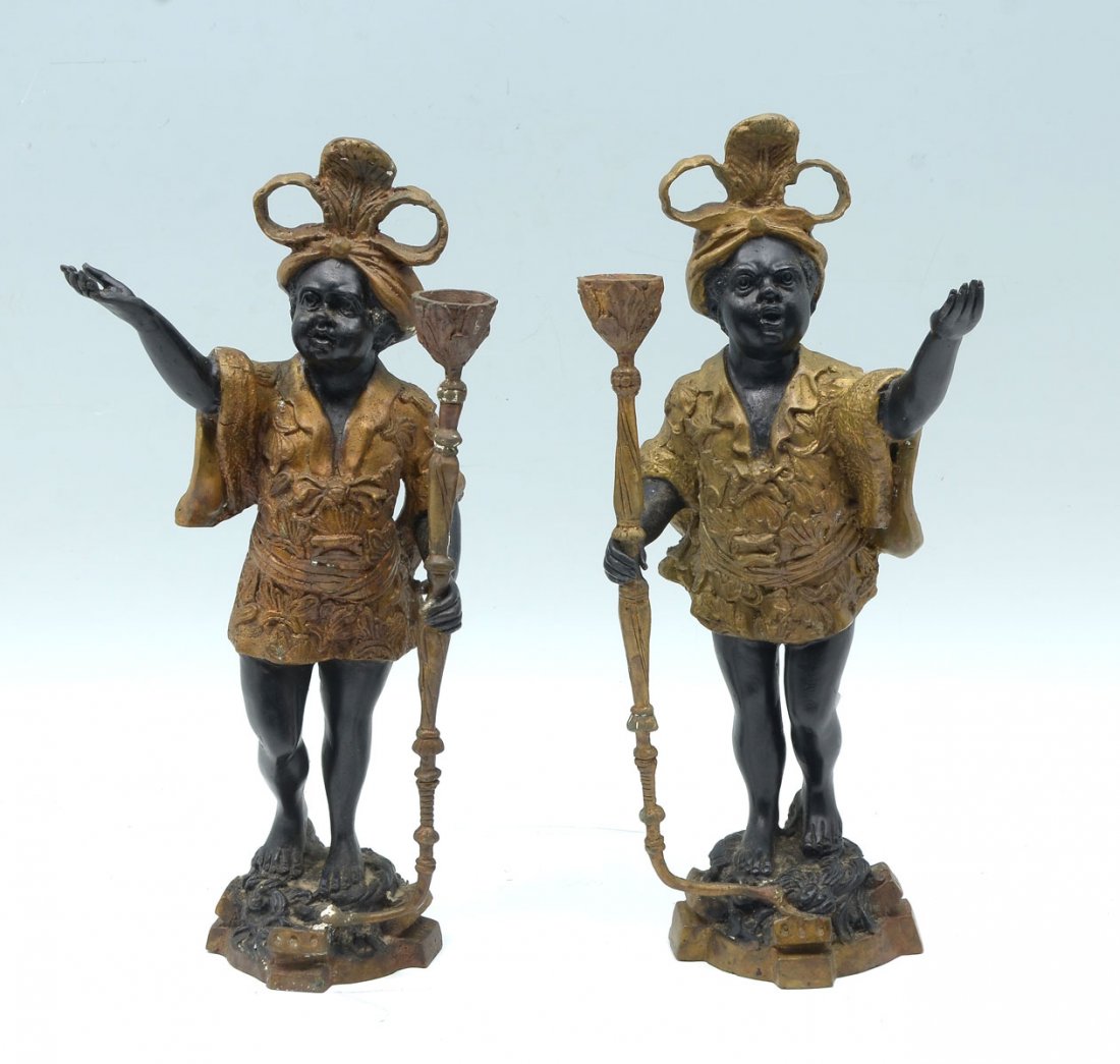 PR CONTEMPORARY BLACKAMOOR BRONZE CANDLE HOLDERS: PR CONTEMPORARY BLACKAMOOR BRONZE CANDLE HOLDERS: 2- Opposing Bronze Blackamoor figures with one hand having a single light candle holder. Approx. 15.5" h x 7" l x 5" w. Weight Approx. 15 Lbs.