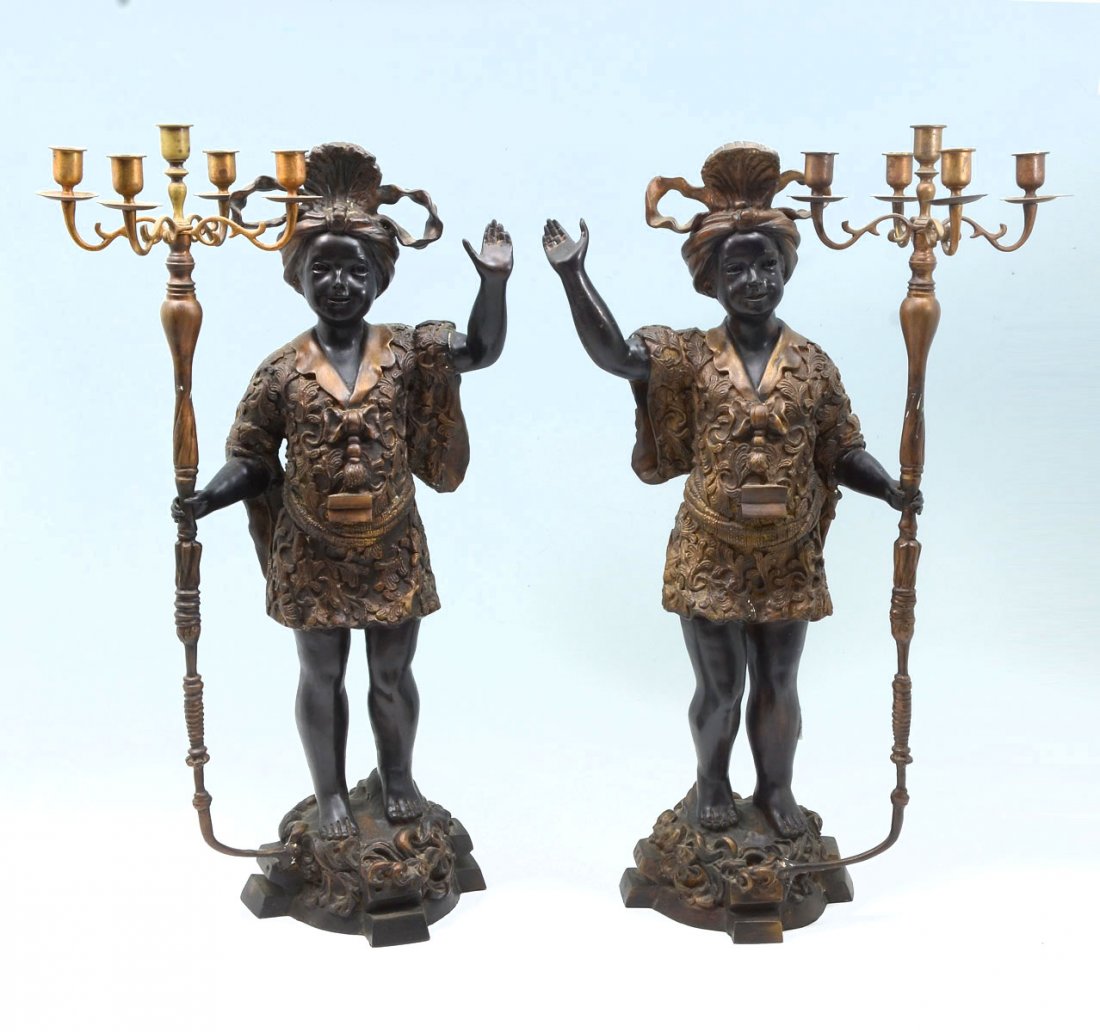 PAIR OF CONTEMPORARY BRONZE BLACKAMOOR CANDELABRA: PAIR OF CONTEMPORARY BRONZE BLACKAMOOR CANDELABRA: 2- Opposing Bronze Blackamoor figures with one hand holding a 5- light candle holder. Approx. 27.25" h x 16.5" l x 10.5" w.