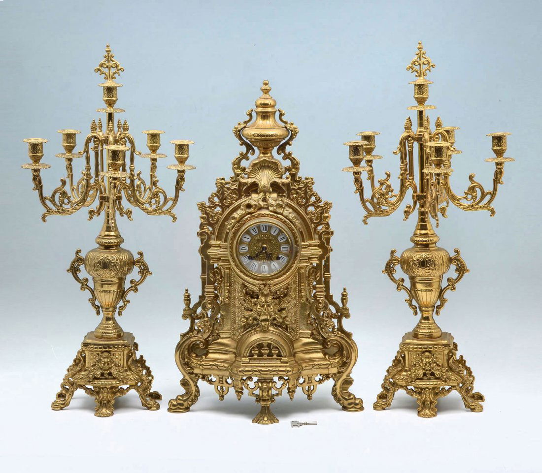 IMPERIAL 3 PIECE BRASS GARNITURE CLOCK SET: IMPERIAL 3 PIECE BRASS GARNITURE CLOCK SET: European style brass case clock with urn finial, North wind masqueron and foliate designs. Marked Imperial on face, key wind Franz Hermel movement. Approx.