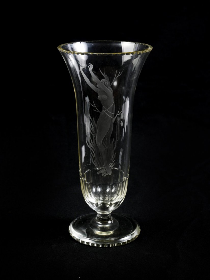 ORREFORS NUDE FOOTED VASE: ORREFORS NUDE FOOTED VASE: Tall footed Orrefors vase, having an etched nude woman tied to a tree, standing in flames. Initialed RV at lower left. Approx. 12.25" h x 5.75" w.