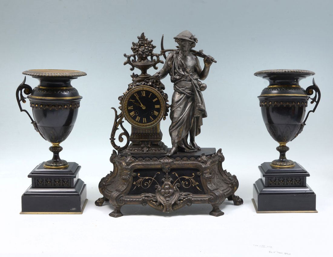 FIGURAL CLOCK AND GARNITURE SET: FIGURAL CLOCK AND GARNITURE SET: Comprising; 1- Spelter & black marble clock with a harvester, 2- Single handled urns raised on black marble bases. Clock Approx. 17.25" h x 15" l x 6" w. Urns Approx.