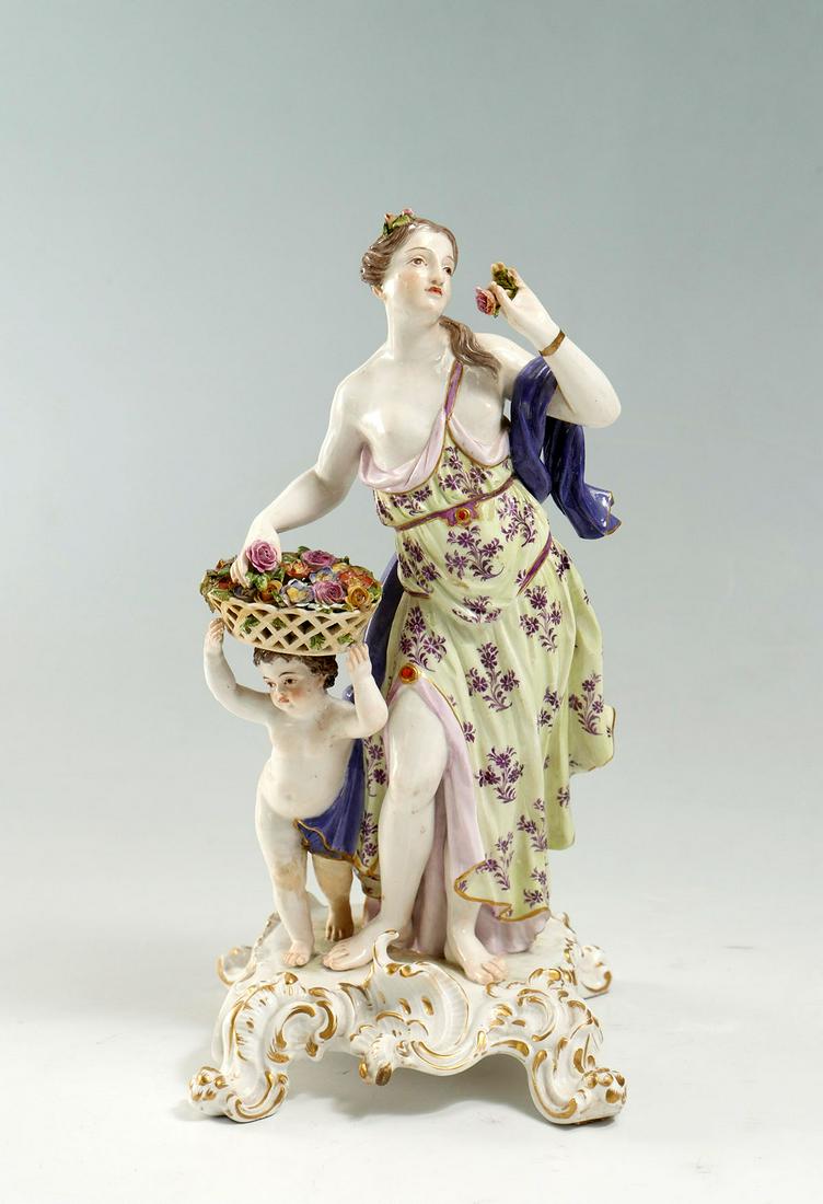 LARGE MEISSEN FIGURE WOMAN WITH BASKET: LARGE MEISSEN FIGURE WOMAN WITH BASKET: Meissen porcelain figure of a woman & child with a floral basket upon head. Raised on a scrolling foliate designed base. Crossed swords mark at underside. Appro