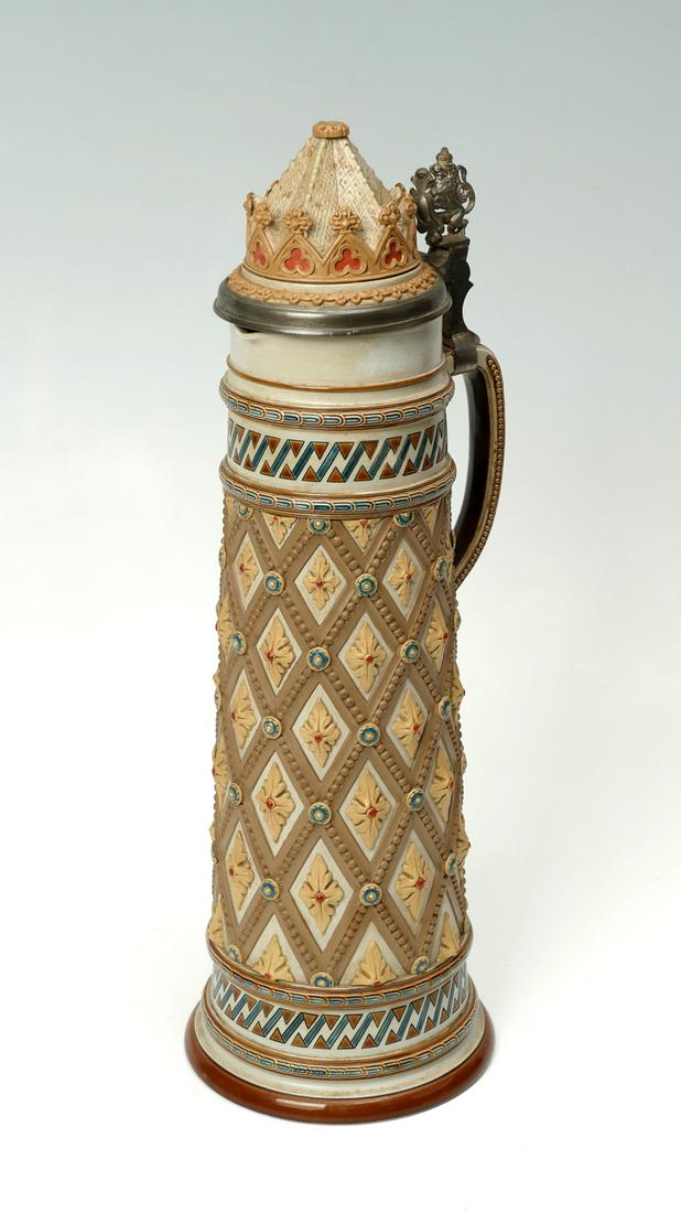 TALL METTLACH STEIN #1780: TALL METTLACH STEIN #1780: 19th century Mettlach stein, having a Lion & heraldic shield thumb lift. Overall foliate medallion & beaded cross section design. Impressed castle mark, # 1780, at underside