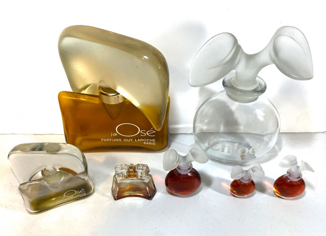 7 PIECE PERFUME BOTTLES: 7 PIECE PERFUME BOTTLES: 1) Karl Lagerfeld Chloe factice perfume bottle in clear glass with enamel label and frosted glass lily stopper - empty; 2) 3 full, smaller Chloe factice bottles; 3) Empty bott