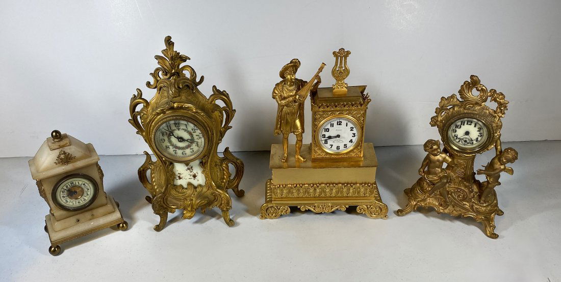 4 FRENCH & GERMAN MANTLE CLOCKS: 4 FRENCH & GERMAN MANTLE CLOCKS: Comprising; 1- Alabaster German clock, 1- 19th C. Gilt bronze boudoir clock with Putti figures, 1- Gilt French, 8- jewel, Hall Du Voyage clock, having a surmounting mu