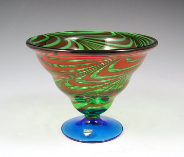 ORREFORS SWEDISH GLASS SWIRL COMPOTE: ORREFORS SWEDISH GLASS SWIRL DECORATED COMPOTE: Blue glass stem supports the green glass bowl with red swirls. Paper label and acid etched ''Orrefors''. 4 1/2''h., 6'' dia.