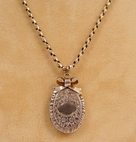 ENGLISH 9K 18" CHAIN WITH ENGRAVED LOCKET: ENGLISH 9K 18" CHAIN WITH ENGRAVED LOCKET: Bow knot gold filled locket. Chain 9k, 18" in length. Chain weighs approx 7.8 grams.
