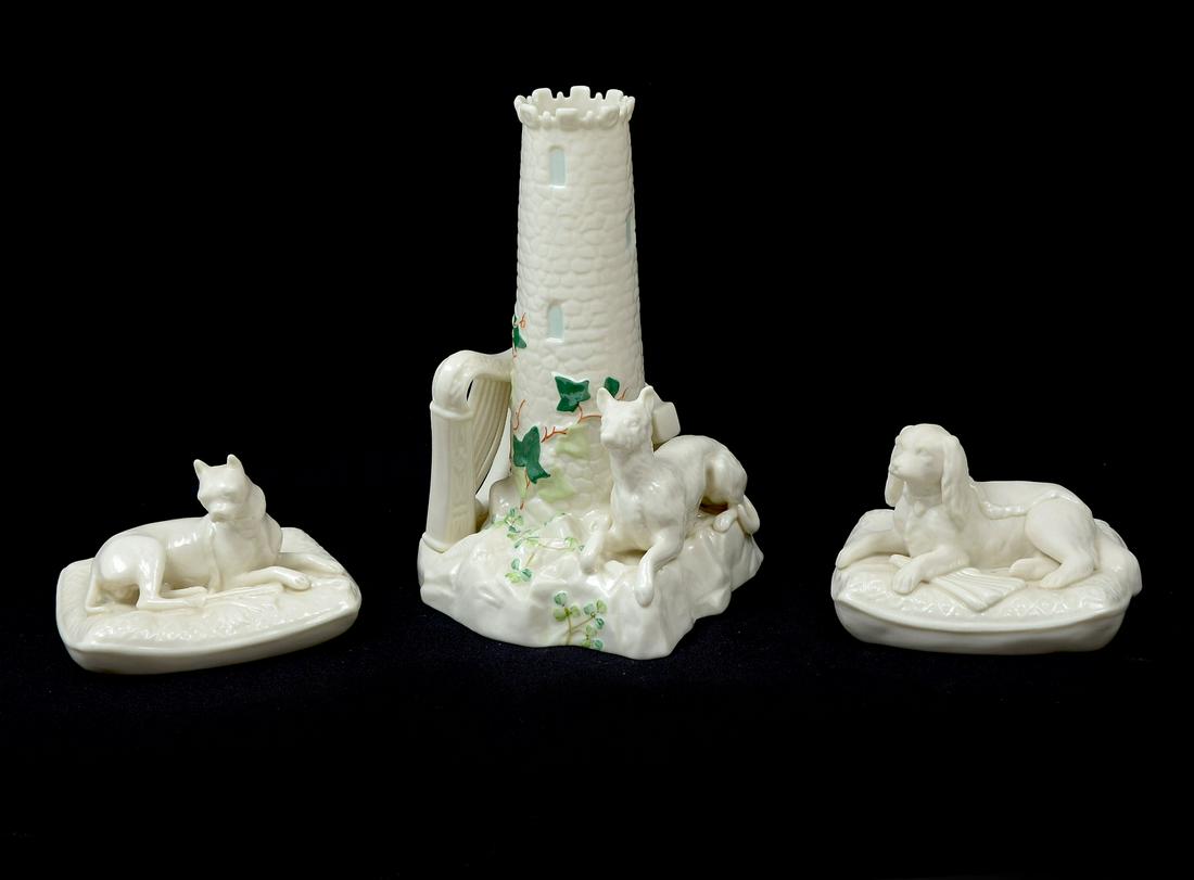 3 PIECE DOG MOTIF BELLEEK: 3 PIECE DOG MOTIF BELLEEK: 1) 6th green mark Boxer lounging on a pillow by his ''stash''. Measures 3.25'' h and is 4.75'' x 4'' at the base; 2) 6th green mark Cavalier King Charles bisque spaniel on a
