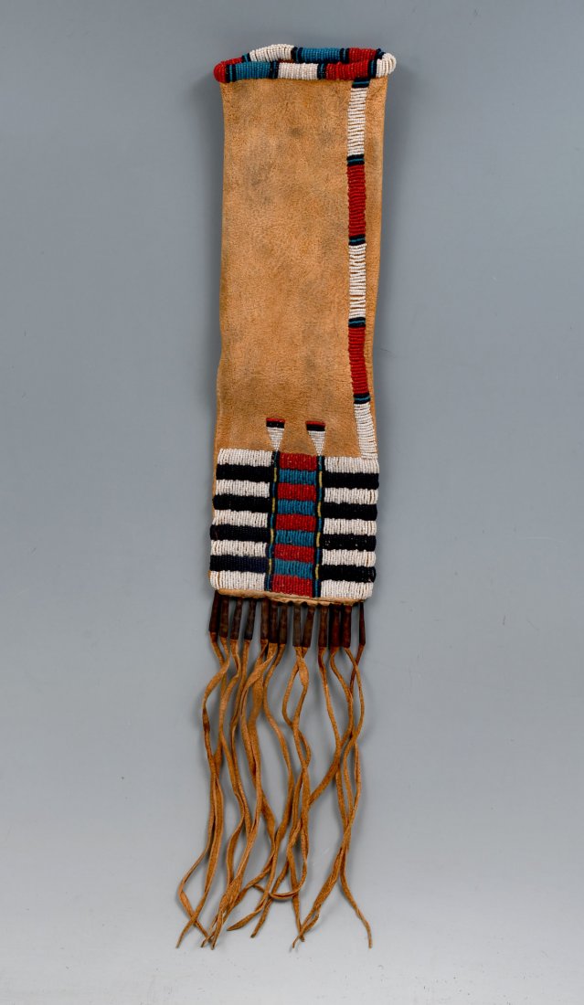 NATIVE AMERICAN INDIAN BEADED HIDE TOBACCO BAG: NATIVE AMERICAN INDIAN BEADED HIDE TOBACCO BAG: Cheyenne beaded tobacco bag on soft hide with hide fringe cascading from the lower seam and tin cones lining the upper edge of the fringe. Bottom quarte
