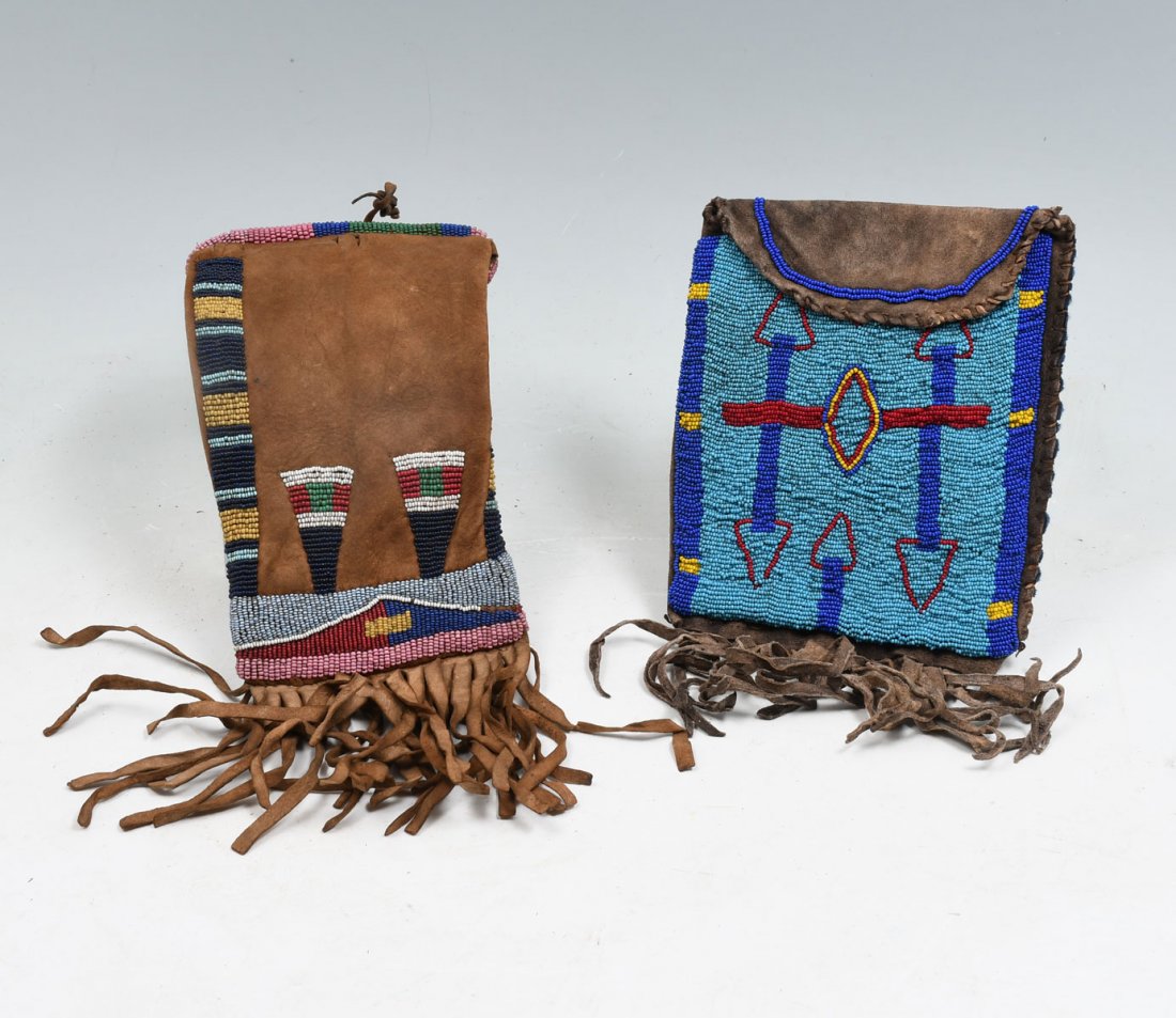 2 NATIVE AMERICAN INDIAN BEADED HIDE TOBACCO BAGS: 2 NATIVE AMERICAN INDIAN BEADED HIDE TOBACCO BAGS: 1) Tobacco bag beaded on soft hide with lower seam featuring cascading hide fringe. Front of pouch is fully beaded with bright blue with an arrow des