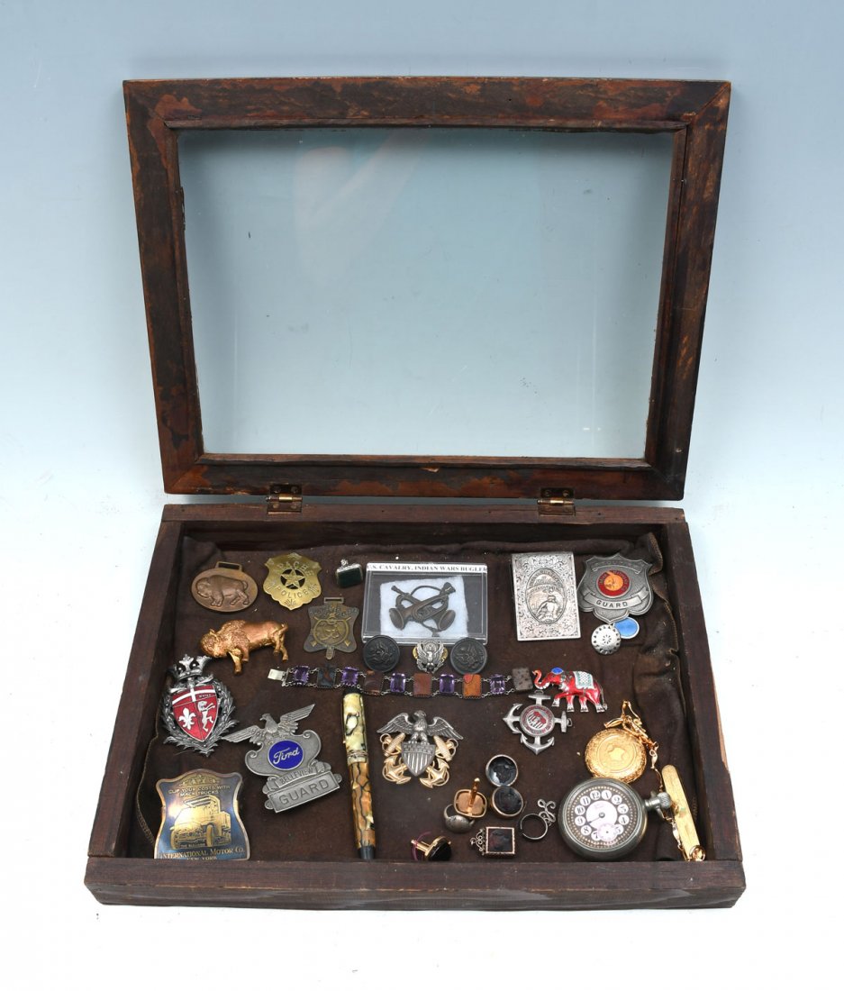 BOX OF TRINKETS AND CURIOS: BOX OF TRINKETS AND CURIOS: Wonderful assortment of badges, clips and buckles representing American Indians, Buffalo and U.S. Military. Also includes 2 pocket watches, pocketknife and some jewelry.
