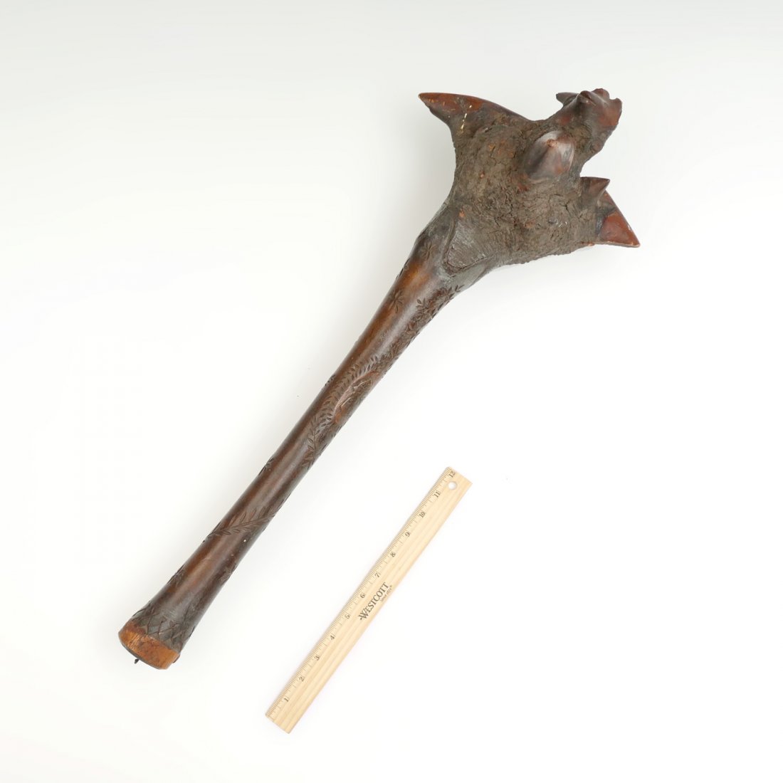 CIRCA 1900 PENOBSCOT NATIVE AMERICAN WAR CLUB: CIRCA 1900 PENOBSCOT NATIVE AMERICAN WAR CLUB: Maine Native American Indian carved figural birch root war club, featuring a wolf's head. Some bark remaining. Handle has a chip-carved foliate design wi