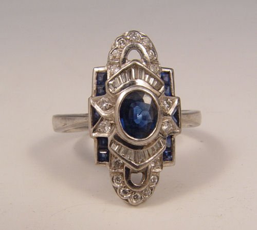 18k DECO STYLE SAPPHIRE & DIAMOND RING SIZE 9.25: DECO STYLE 18K DIAMOND & SAPPHIRE RING: 18K white gold ring contains one oval cut sapphire, 8 square calibre cut sapphires and 2 triangle cut sapphires. Weight: 1.50 Ct. Approx. The sapphires average 