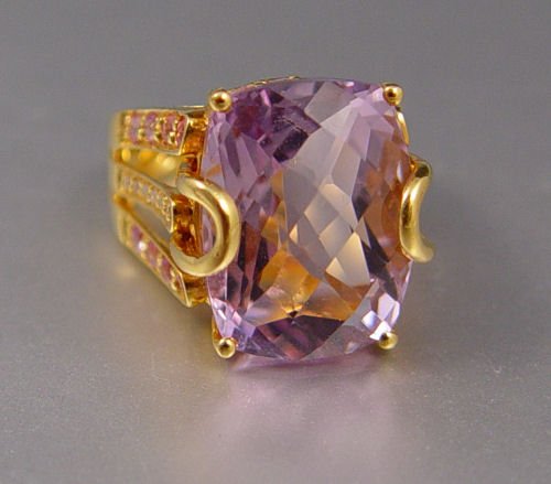 22K 12 CT AMETHYST RING W/ SAPPHIRES: 12 CT CUSHION CUT AMETHYST RING WITH PINK SAPPHIRES AND DIAMONDS: 22K yellow gold ring featuring a 12 ct cushion cut amethyst, VVS in clarity, P hue, 2 tone and 2 in saturation. The shank contains 24