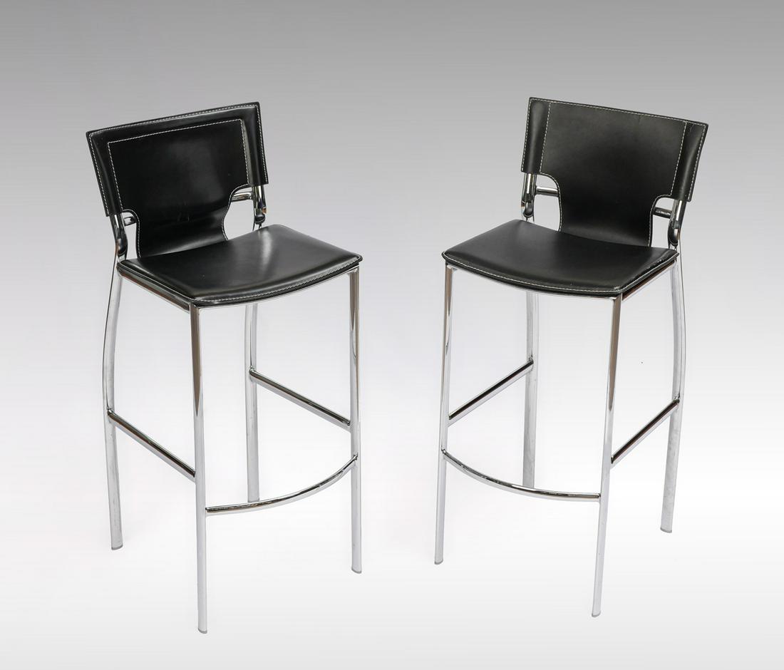 PAIR OF MODERN CHROME BAR STOOLS: PAIR OF MODERN CHROME BAR STOOLS: Black faux leather upholstered bar stools, having a chromed frame. Approx. 39.5'' h x 19.75'' l x 16.25'' w.