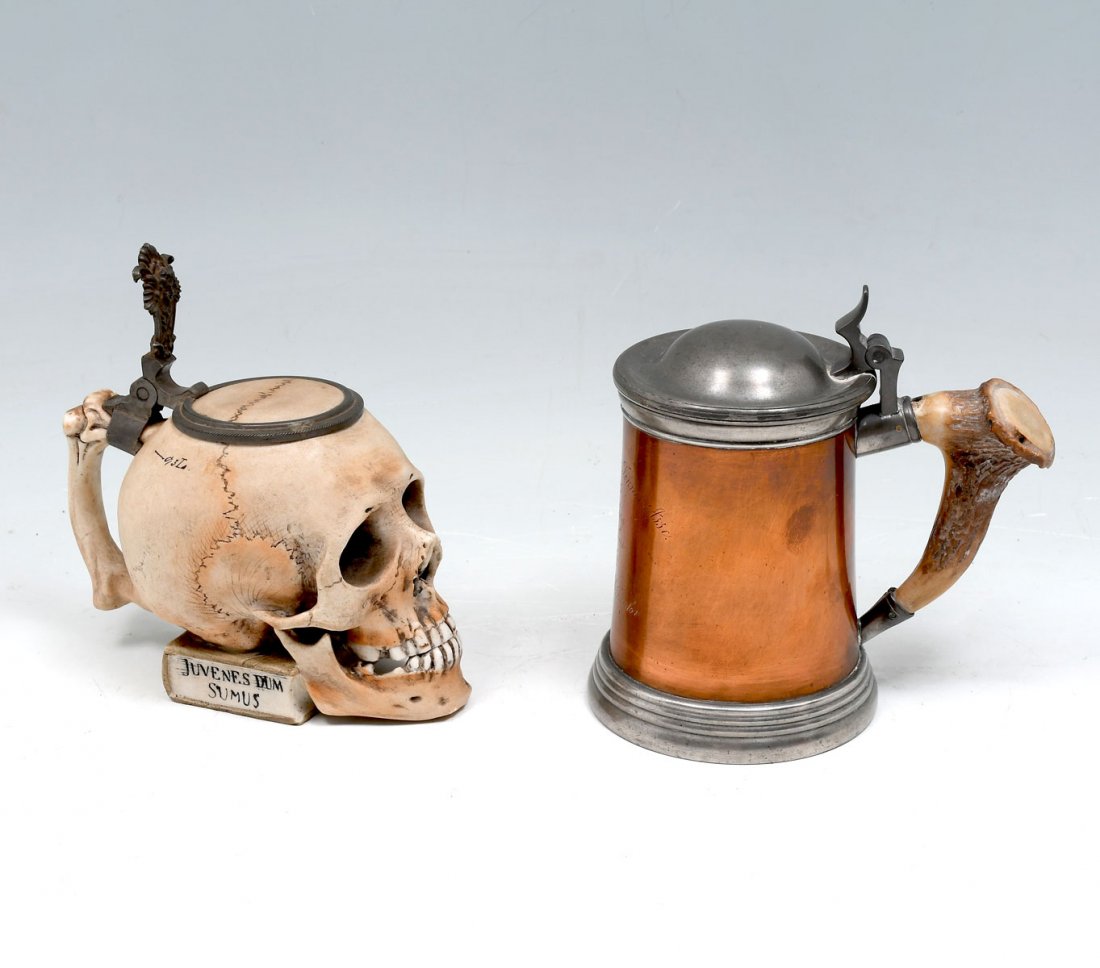 2 PC. COPPER & PORCELAIN SKULL TANKARDS: 2 PC. COPPER & PORCELAIN SKULL TANKARDS: 1- Porcelain & pewter skull form tankard, & 1- Glass bottom copper bowling award mug, dated 1905, having an antler handle. Made in Boston. Largest Approx. 6.25