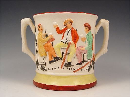 PRATTWARE DOUBLE HANDLE MUG WITH FROG: PRATTWARE DOUBLE HANDLE MUG OR LOVING CUP WITH FROG: "Willie Brewed a Peck o Malt", raised figures of men sharing a brew. Interior with a large frog. 5 1/4"h. x 7" dia. handles included.
