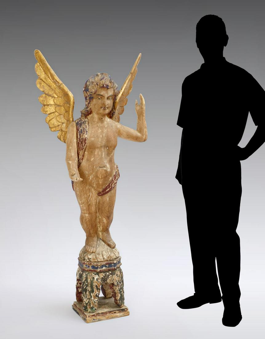 LARGE CONTINENTAL EARLY CARVED WOODEN ANGEL: LARGE CONTINENTAL EARLY CARVED WOODEN ANGEL: Carved & polychrome angel standing on a foliate form base. Gilt wings. Approx. 63.25'' h x 26.5'' l x 21'' w. Approx. 36 pounds!