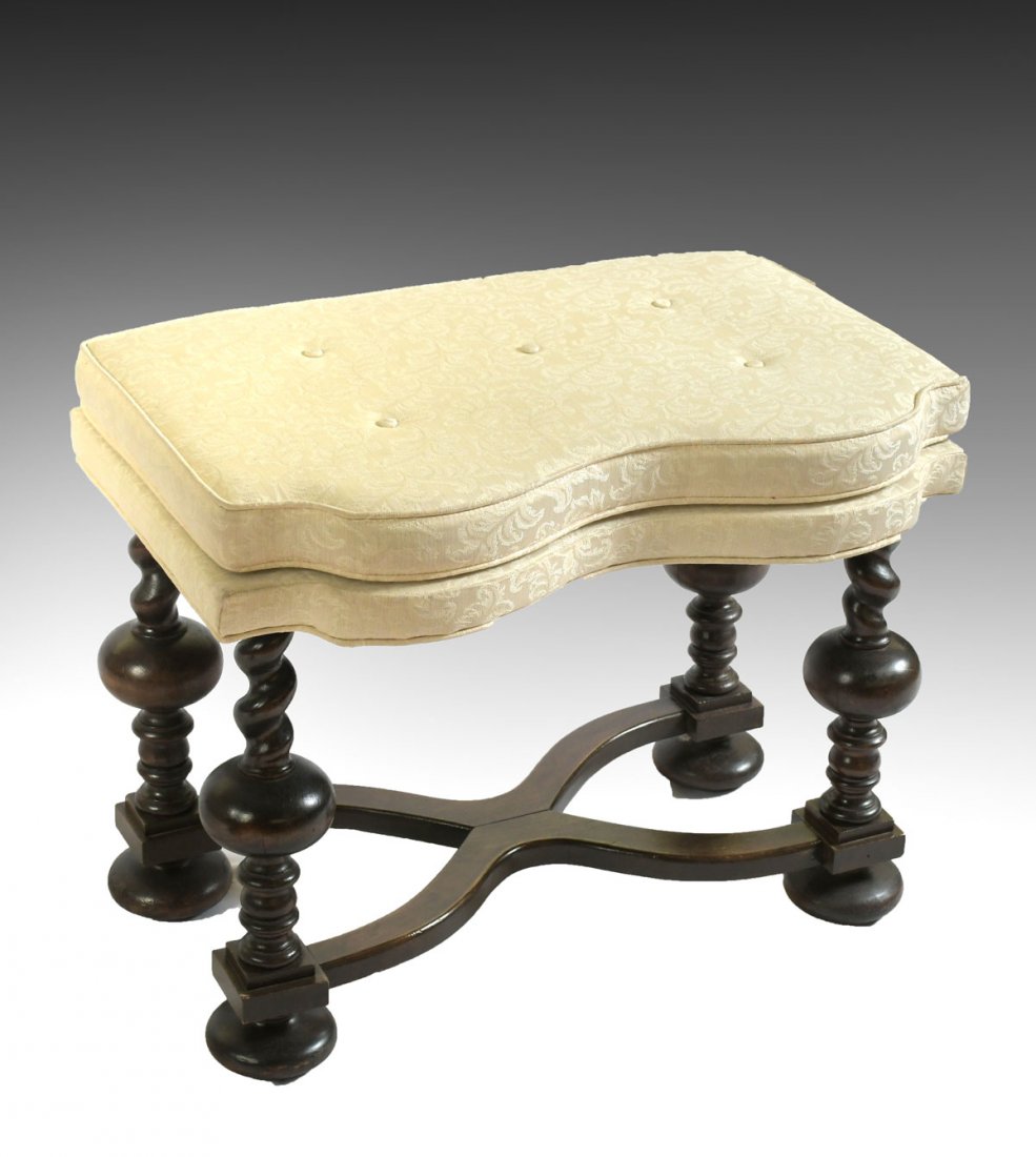 CARVED ENGLISH FOOTSTOOL: CARVED ENGLISH FOOTSTOOL: Having carved spiraling & turned supports. Replaced ''X''-shaped stretcher & married upholstered cushion. Raised on bun feet. Approx. 21'' h x 26.25'' l x 17.25'' w.