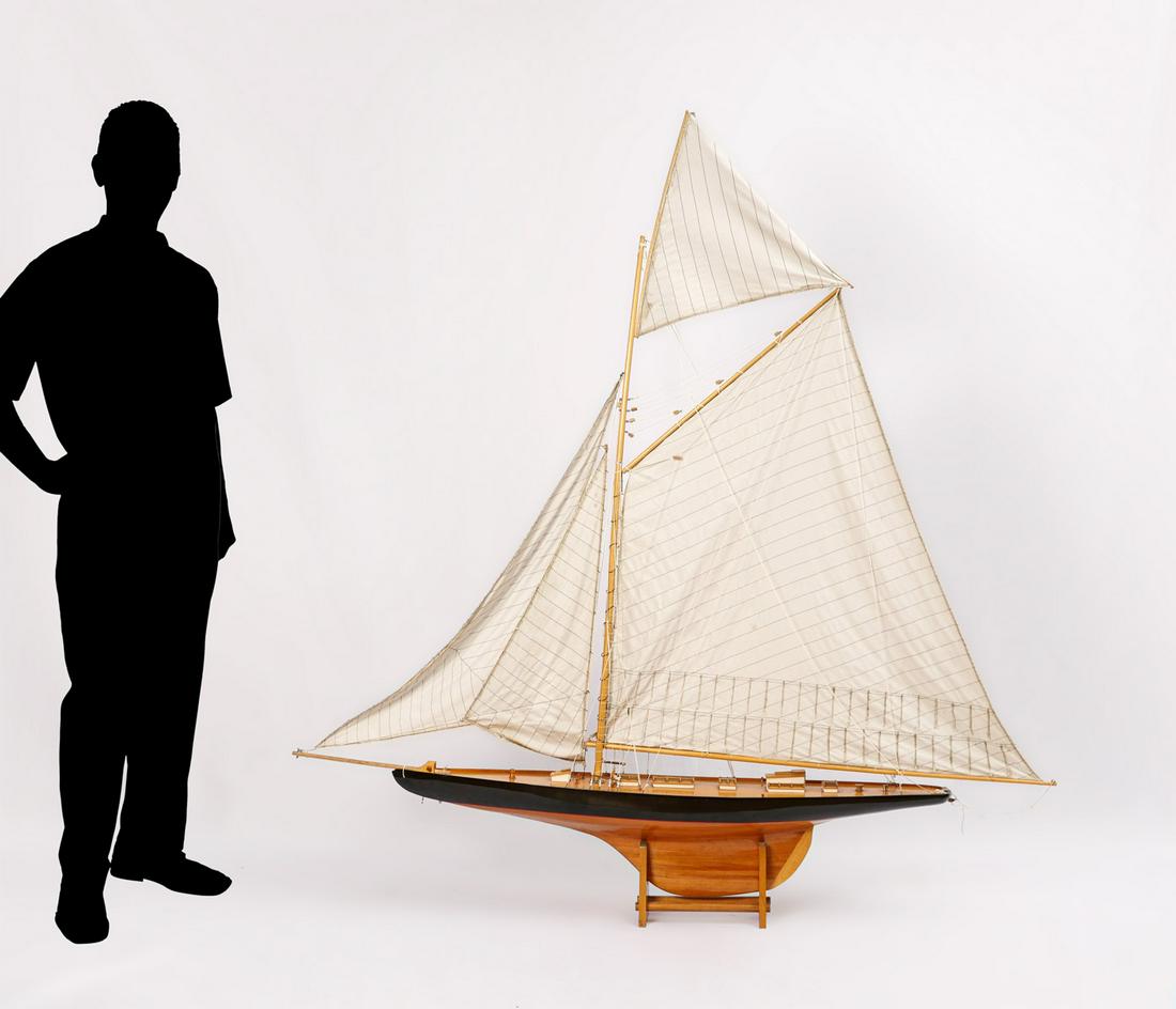 LARGE HANDMADE SAILBOAT MODEL ON STAND: LARGE HANDMADE SAILBOAT MODEL ON STAND: Painted hull, rigged with four cloth sails. Resting on stand. Approx. 69.5" h x 68" l x 9.25" w.
