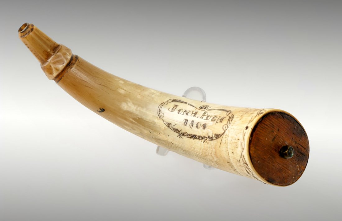JOHN PUGH POWDERHORN: JON H. PUGH 19TH CENTURY SCRIMSHAW POWDER HORN: Early 19th Century scrimshaw decorated powder horn bearing the name Jon H. Pugh and dated 1804 inside a scrimshaw cartouche and on the reverse with a sc