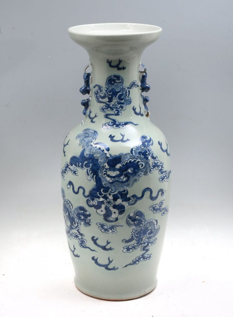 TALL CHINESE BLUE AND WHITE FOO DOG VASE: TALL CHINESE BLUE AND WHITE FOO DOG VASE: Celadon glazed Chinese vase, having blue & white Foo Dogs amongst stylized clouds and flames. Attached Foo Dog handles. Approx. 23.75" h x 9.75" w. Provenance