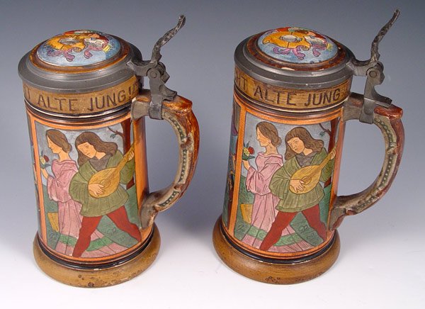 PAIR GERMAN BEER STEINS: PAIR GERMAN BEER STEINS: 3 panel incised renaissance scenes with motto Ein Guter Trunk Macht Alte Jung. Hinged pewter lids with medallion. Marked Germany. Measures 8'' h. x 4'' base dia.