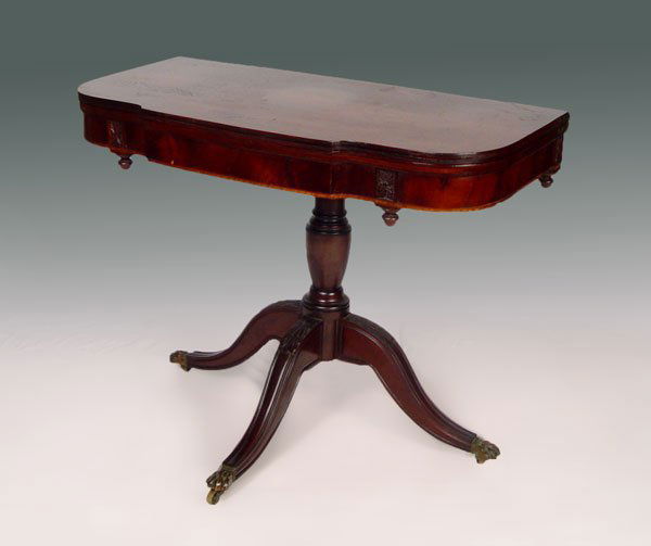 1870'S INLAY MAHOGANY GAME TABLE: 1870'S INLAY MAHOGANY GAME TABLE: Mahogany veneer with string inlay. Block front design with carving over drop finials. Turned base supported by 3 splayed legs and carved paw feet. 28 1/2'' h. x 35 1/