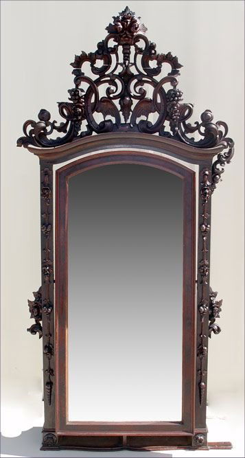 ROSEWOOD & MAHOGANY CARVED CHEVAL MIRROR: RICHLY CARVED ROSEWOOD AND MAHOGANY CHEVAL MIRROR: Full length beveled, arched top, swivel mirror framed in mahogany, adorned with a rich rosewood carving of cornucopia of roses, grape clusters, wings