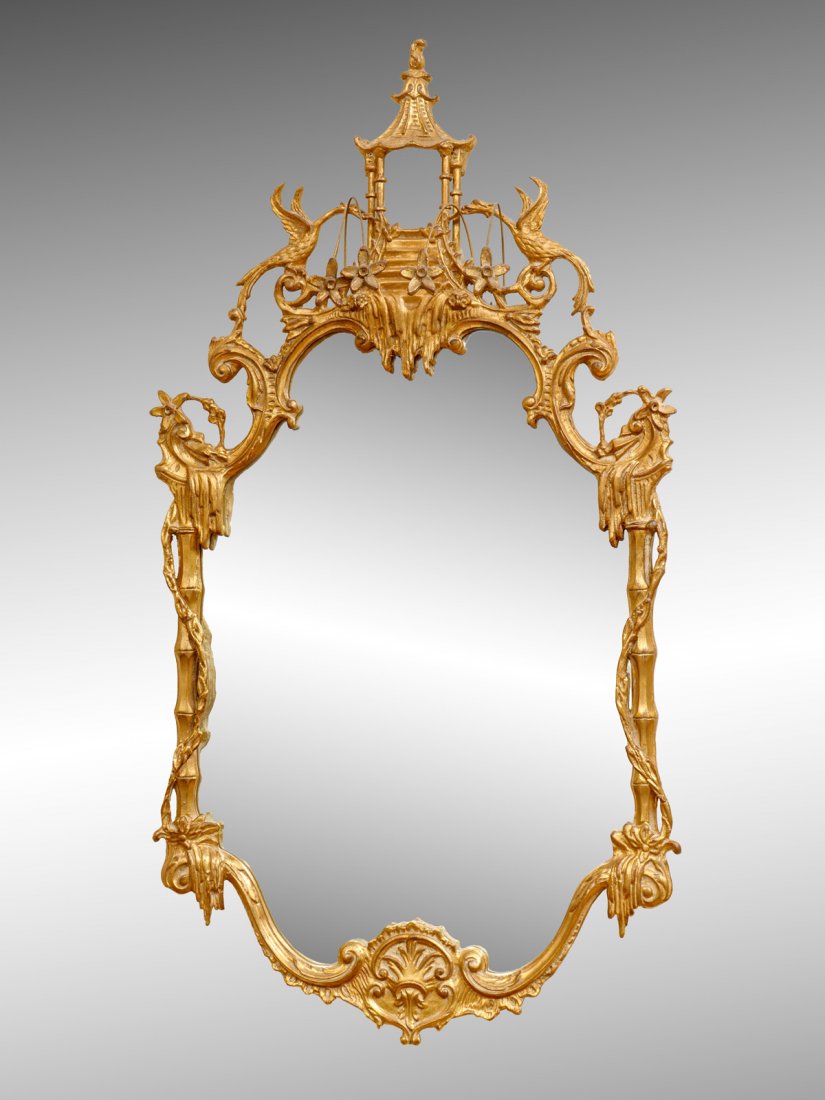 CHINESE CHIPPENDALE STYLE GILTWOOD MIRROR: CHINESE CHIPPENDALE STYLE GILTWOOD MIRROR: Surmounting pagoda flanked by phoenix birds and attached carved flowers. Scrolling foliate designed frame. Approx. 48.5'' h x 26'' l x 6.5'' w.