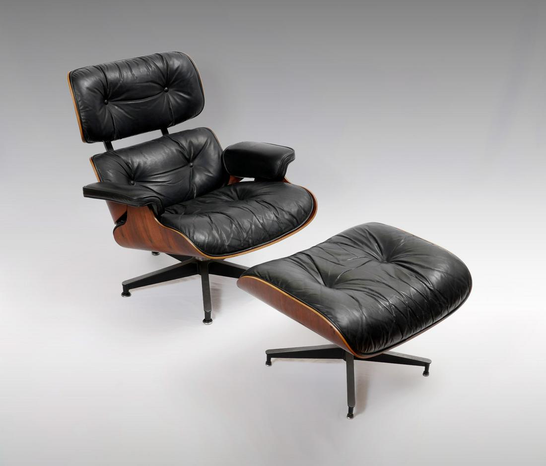 HERMAN MILLER LEATHER EAMES CHAIR AND OTTOMAN: HERMAN MILLER LEATHER EAMES CHAIR AND OTTOMAN: Black leather chair & ottoman, having a cherry bent wood frame. Herman Miller tag resides at underside. Chair Approx. 32.25'' h x 33'' l x 35'' w. Ottoma